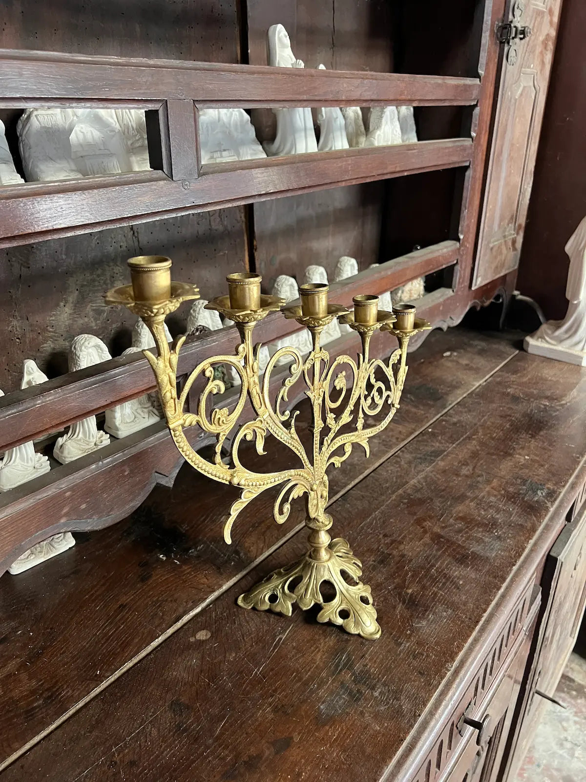 Antique gilded bronze altar candelabrum with five lights and ornate scrollwork design, perfect for liturgical use or sacred art display.
/
Candélabre d’autel ancien en bronze doré à cinq bougeoirs et décor de volutes, idéal pour usage liturgique ou exposition d’art sacré.