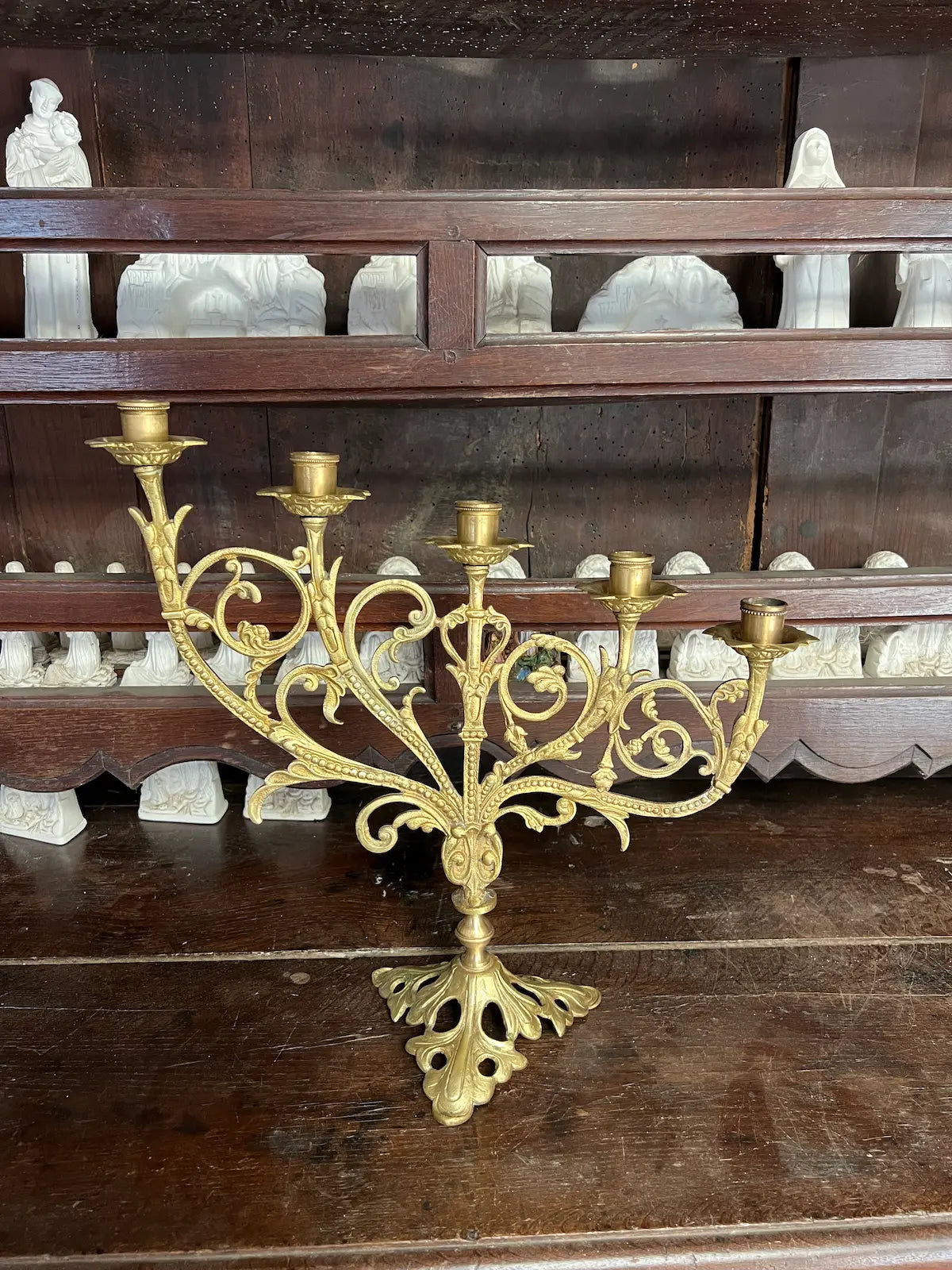 Antique gilded bronze altar candelabrum with five lights and ornate scrollwork design, perfect for liturgical use or sacred art display.
/
Candélabre d’autel ancien en bronze doré à cinq bougeoirs et décor de volutes, idéal pour usage liturgique ou exposition d’art sacré.