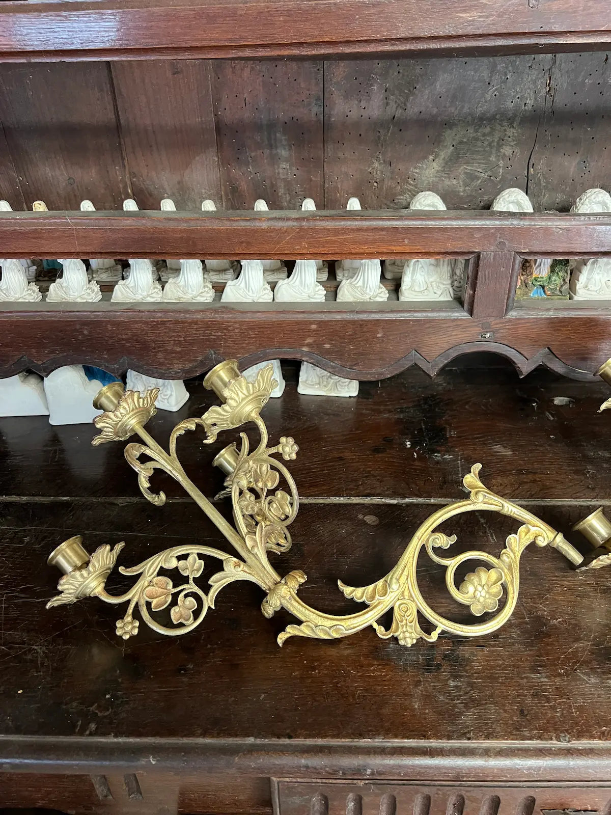Pair of antique gilded bronze wall candelabra with five lights and ornate floral scrollwork, perfect for churches or decorative interiors.
/
Paire d’appliques murales anciennes en bronze doré à cinq bougeoirs et volutes florales, idéales pour églises ou intérieurs décoratifs.