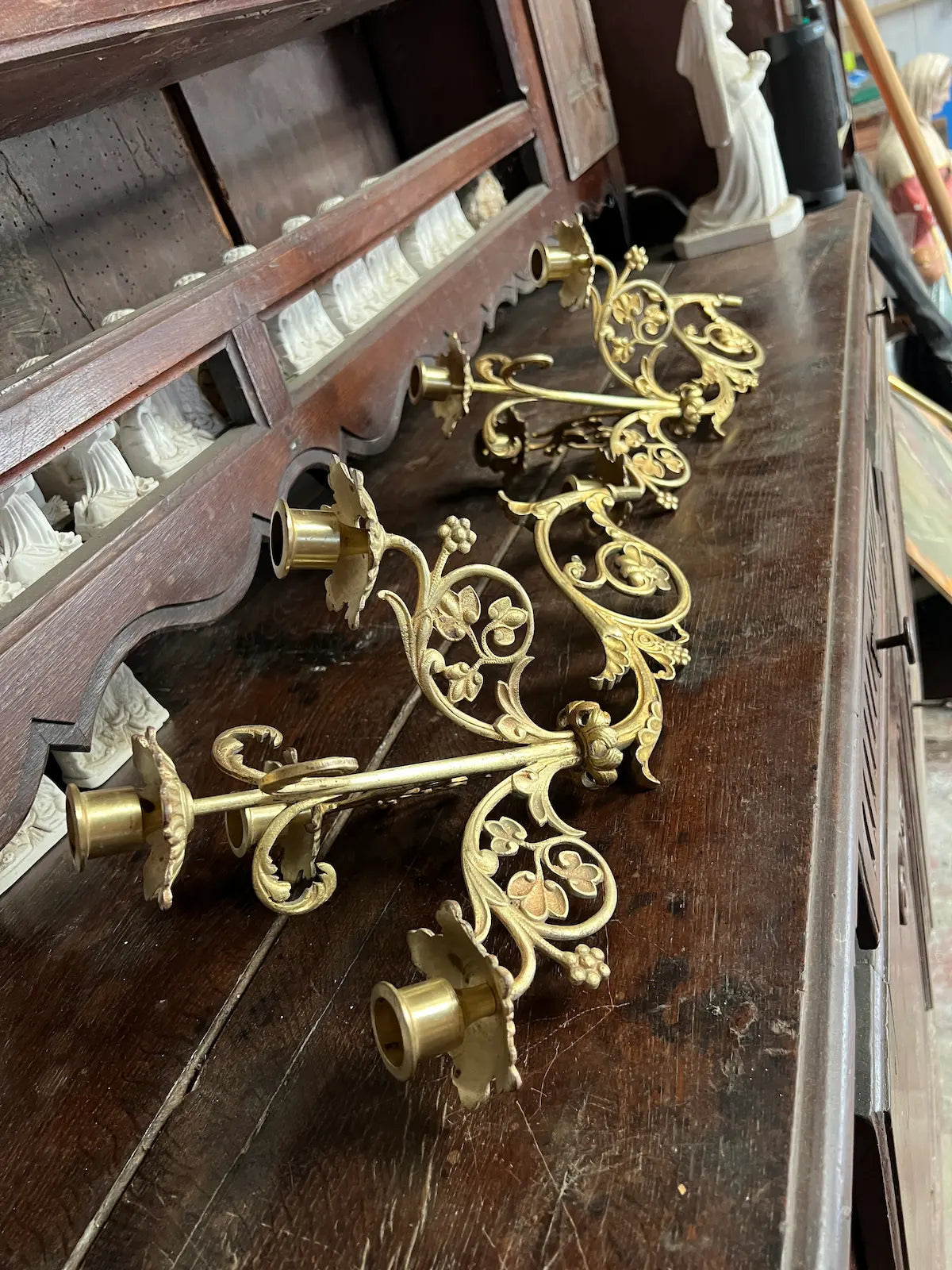 Pair of antique gilded bronze wall candelabra with five lights and ornate floral scrollwork, perfect for churches or decorative interiors.
/
Paire d’appliques murales anciennes en bronze doré à cinq bougeoirs et volutes florales, idéales pour églises ou intérieurs décoratifs.
