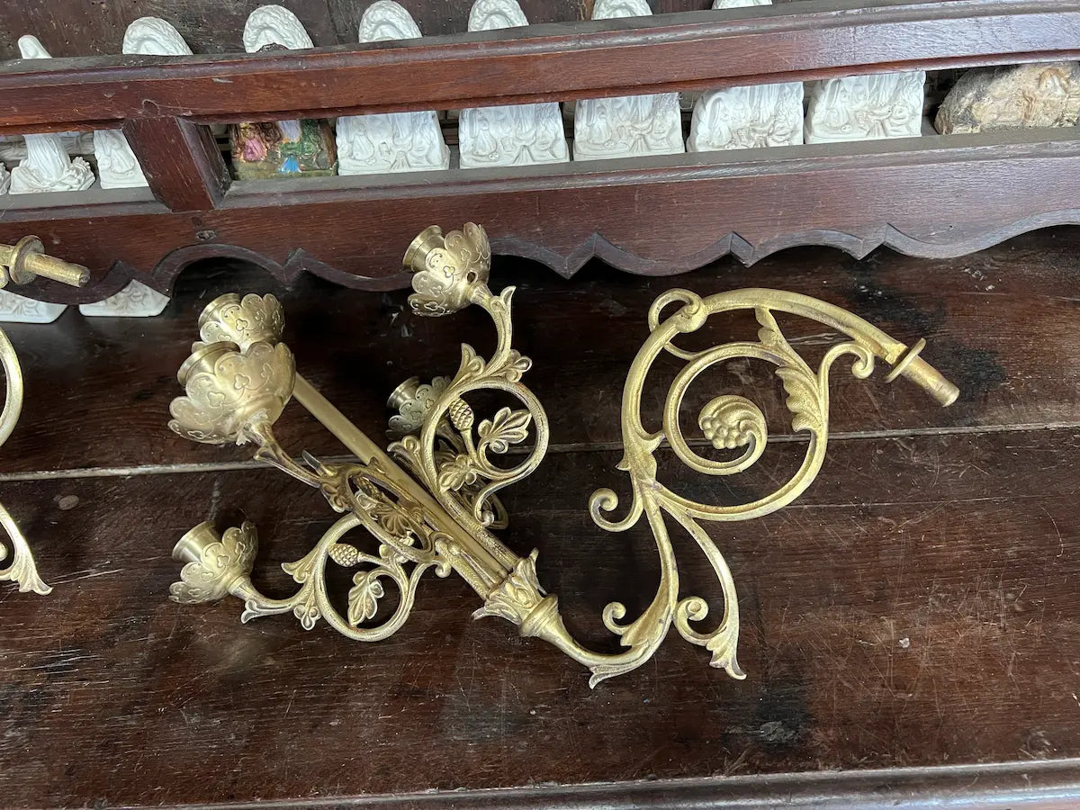 Pair of antique gilded bronze wall candelabra with five lights and ornate floral scrollwork, perfect for church or decorative use.
/
Paire d’appliques murales anciennes en bronze doré à cinq bougeoirs et volutes florales, idéales pour église ou décoration.