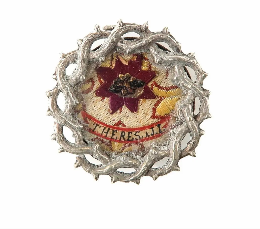 Sealed theca with relic of St. Thérèse of the Child Jesus, crown-of-thorns mount, with certificate of authenticity.
/
Thèque scellée avec relique de Sainte Thérèse de l’Enfant Jésus, monture en couronne d’épines, avec certificat d’authenticité.