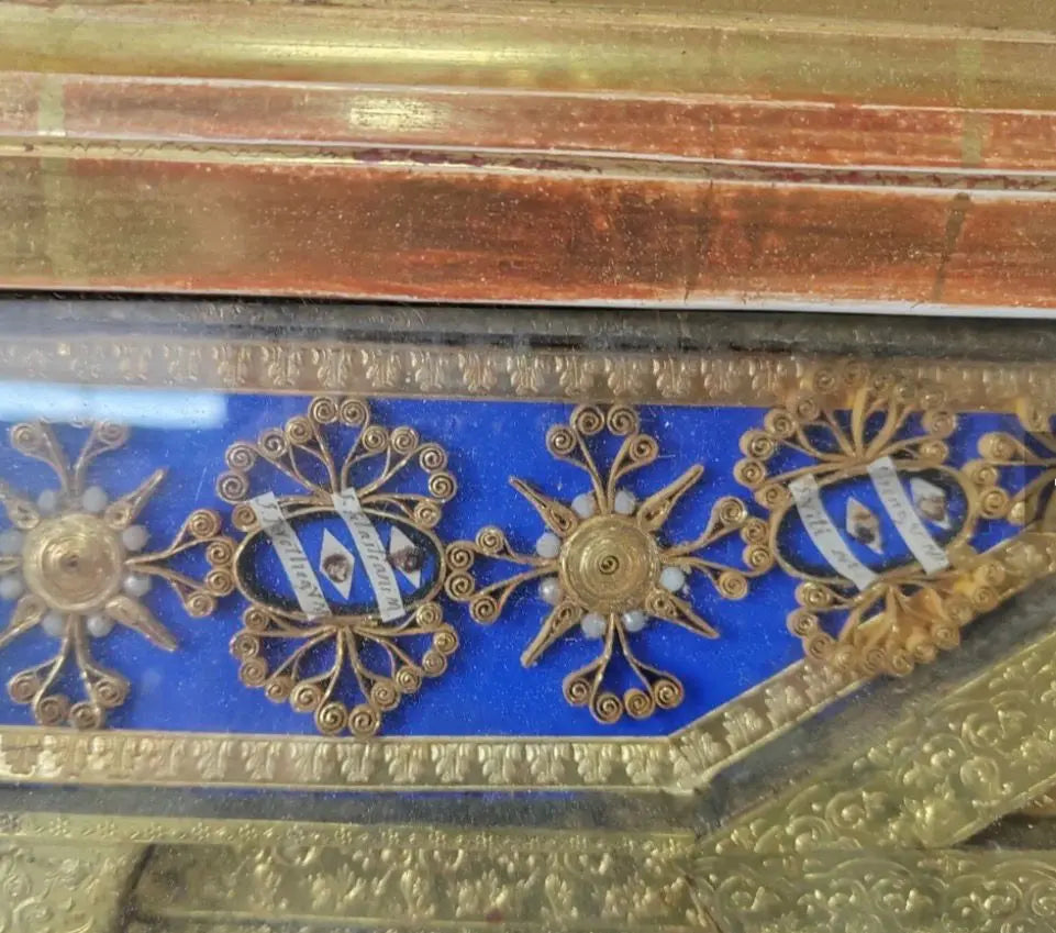 Antique gilded reliquary frame with miniature chapel altars and multiple authentic relics of saints.
/
Cadre reliquaire ancien doré avec chapelles miniatures et reliques authentiques de plusieurs saints.