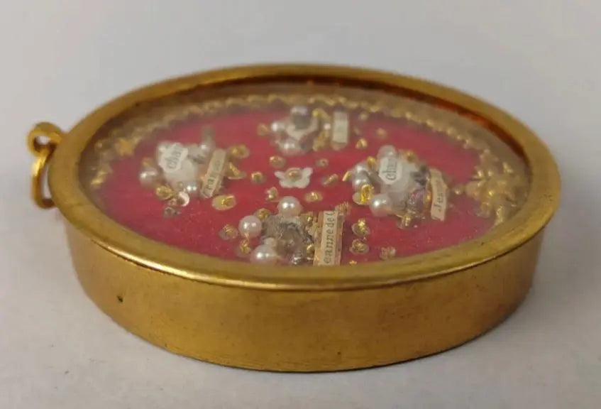 Antique oval reliquary containing relics of St. Francis de Sales and St. Jane de Chantal on red velvet background.
/
Reliquaire ovale ancien contenant des reliques de saint François de Sales et sainte Jeanne de Chantal sur fond en velours rouge.