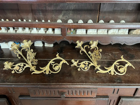 Pair of antique gilded bronze wall candelabra with five lights and ornate floral scrollwork, perfect for churches or decorative interiors.
/
Paire d’appliques murales anciennes en bronze doré à cinq bougeoirs et volutes florales, idéales pour églises ou intérieurs décoratifs.